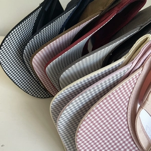 Close-up of assorted cotton gingham baseball caps showing textile texture and stitching