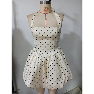 Détail de la robe licou blanche à pois avec ourlet bulle et coupe cintrée à la taille