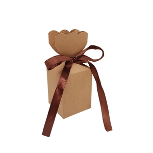 Detail of kraft paper gift box with wavy flower edge and dark brown ribbon bow
