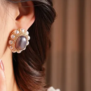 Vintage style gold-toned stud earrings with purple-grey cabochon stone and pearls