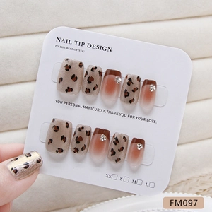 Handmade brown French leopard cat-eye press-on nails set with rhinestones on a white card