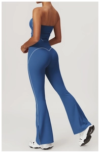 Close-up of high-waist flared yoga pants with white contrast stitching and side slit detail