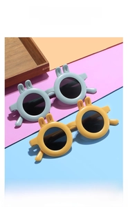 Close-up of kids round sunglasses with cute rabbit ears in blue and yellow colors