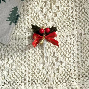 Détail de décoration de gâteau de Noël avec feuille de houx, ruban rouge et clochette