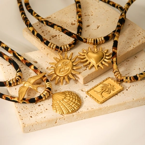Set aus Goldanhängern mit Sonnen- und Muschelmotiven an Leoparden-Stoffbändern