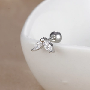 Vue macro détaillée du piercing d'oreille argenté avec zircons en forme de feuilles