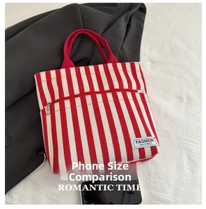 Detail of red and cream striped canvas tote bag with front zipper pocket and fabric label