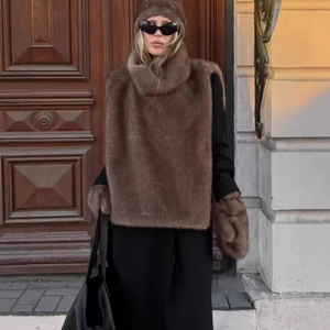 Ensemble écharpe, bonnet et manches en fausse fourrure marron porté avec un manteau noir