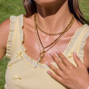 Detail einer mehrlagigen Goldkette mit Perlenstrang und Anhänger am Modell