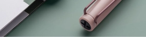 Gros plan du capuchon de stylo rose poudré mat avec un clip à fente cruciforme