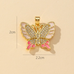 Detailed view of gold butterfly pendant with pink enamel and size marking 2cm x 2.2cm