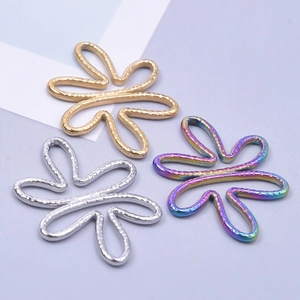 Detailed macro view of hollow flower metal charms in gold, silver and colorful gradients