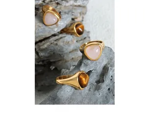 Detailed shot of retro gold stainless steel rings with rose quartz and tiger eye stones