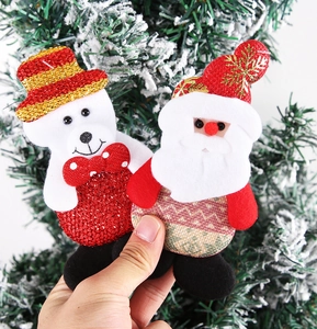 Close-up of Santa Claus and bear fabric ornaments on a Christmas tree background