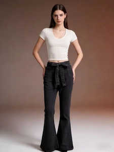 Detail view of high waisted black flare jeans with lace-up front and slim fit white T-shirt