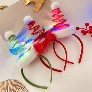 Close-up of three festive plush Christmas headbands with LED lights and bells