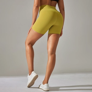 Rear view of high-waisted mustard yellow yoga shorts showing push-up lifting effect