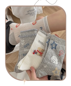 Close-up of gray cotton mesh socks with cute puppy patterns and breathable knit texture