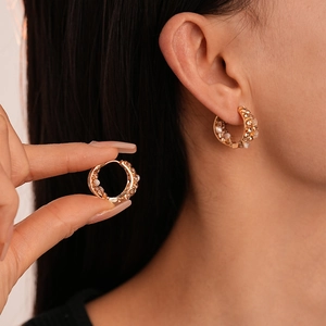 Créoles dorées vintage avec perles blanches et zircons portées par un mannequin