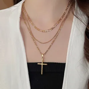 Three-layer 18k gold plated necklace with cross pendant and Figaro chains on model