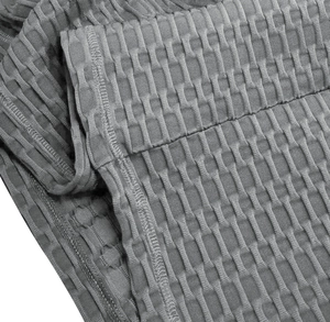 Détail du tissu gaufré gris avec coutures renforcées sur un t-shirt de sport pour homme