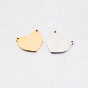 Flat lay of heart-shaped stainless steel charms in gold and silver with double loops