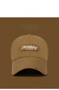 Detail of distressed cotton baseball cap with Thinking WISHFUL embroidery and frayed edges