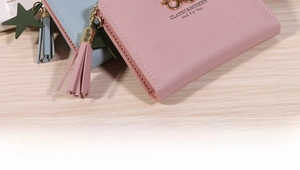 Detail of pink and blue PU leather wallets with star charms and fringe zipper pulls