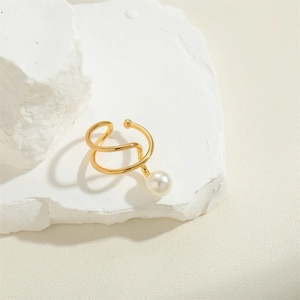 Minimalist gold geometric ear cuff with a single white pearl on a clean stone surface
