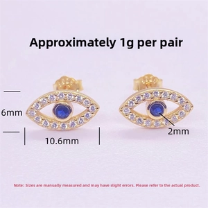 Macro shot of gold S925 silver Evil Eye stud earrings with blue and white zircon stones