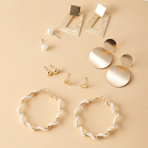 Close-up of 6-piece gold earring set with geometric hoops and faux pearl charms