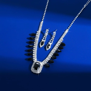 Detailed view of silver necklace and earrings set with black crystal and rhinestones