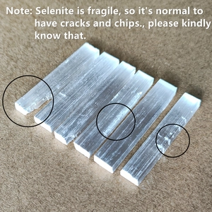 Set of six natural white selenite sticks with fibrous texture on wooden background