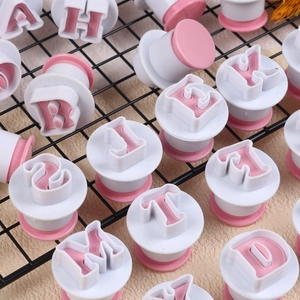 Macro detail of white and pink letter and number plunger cutters for cookie baking