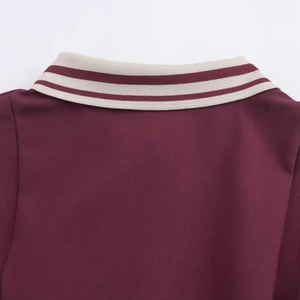 Détail du col polo avec rayures beige sur la robe courte en tricot rouge foncé
