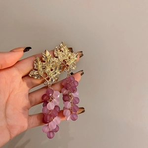Close-up of gold leaf stud with purple and pink frosted beads in a grape cluster design