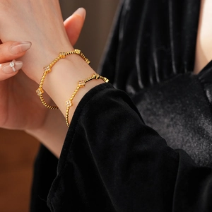 Dettaglio del bracciale a quadrifoglio placcato oro 18k con zirconi indossato dal modello
