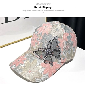 Detailed view of women's lace baseball cap with sparkling rhinestone butterfly decor