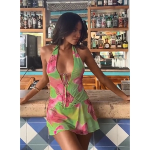 Detail of green and pink floral halter neck dress with deep V-neck and open back design