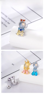 Macro shot of cubic zirconia mermaid studs with screw-back design in gold and silver