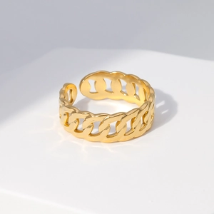 Macro detail of 18K gold Cuban link chain ring with high-polished metallic finish