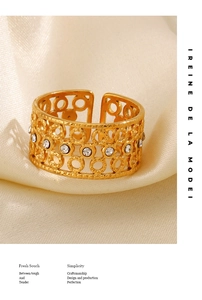 Detail of 18K gold plated hollow geometric ring with white zircon on champagne satin