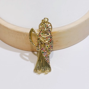 Macro detail of gold Grim Reaper pendant with multi-colored crystals on wooden stand