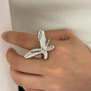 Close-up of a silver butterfly open ring with a 3D fluid design worn on a finger