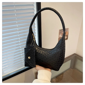 Close-up of black woven texture shoulder bag with small detachable coin purse and gold chain