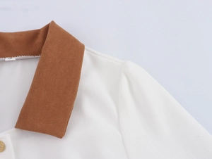 Detail of retro contrast lapel collar with golden button and soft knit texture