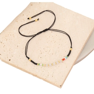 Handmade colorful beads woven black cord bracelet on a minimalist stone base