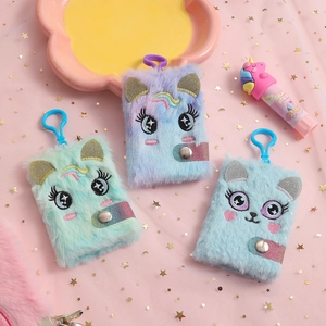 Dettaglio di mini quaderni unicorno in peluche con ricami e ganci su rete rosa