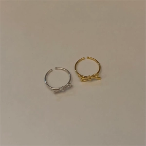 Detailed close-up of S925 sterling silver bow rings in gold and silver finishes