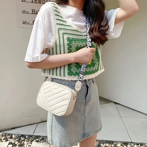 Detail of cream quilted camera bag with stylish wide jacquard crossbody shoulder strap